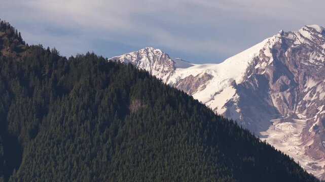 Aerial zoom shot of Mount Rainier glacier fields massive stratovolcano and forested slope from Ashford Washington in summer