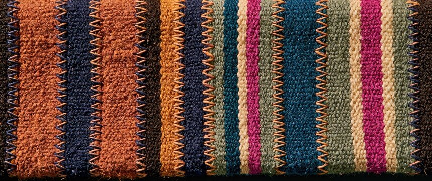 Detailed close-up of a woven fabric with vertical stripes and zigzag stitching