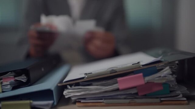 Stack of Business Documents, Bills and Office Files Awaiting Processing on Corporate Desk