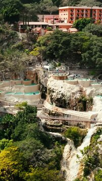 People relaxing in the thermal pools of Grutas Tolantongo, Mexico in vertical aerial view