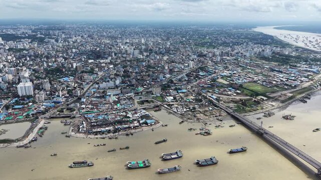 A wide-angle drone perspective reveals a massive gathering of lighter ships scattered across the brown waters of the Karnaphuli River after port operations were halted in Chattogram, Bangladesh. 