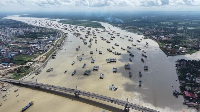 A high-altitude drone shot displays the vast scale of maritime congestion as cargo vessels shelter upstream on the Karnaphuli River in Chattogram, Bangladesh. 