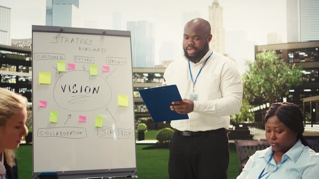 Black business presenter pointing at vision board with sticky notes during strategy workshop, explaining growth plan and sharing ideas for innovation, informal outdoor discussion.