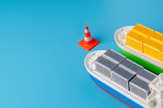 Cargo ships halted by a traffic cone. Supply chain disruptions, port congestion, maritime trade route blockages, shipping delays, and global logistics warnings concept.
