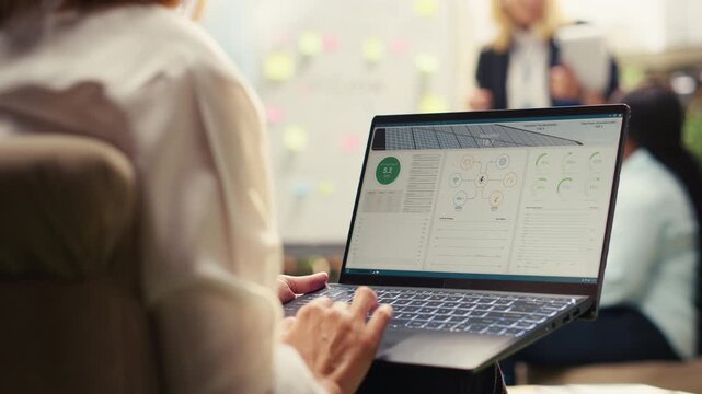 Business employee reviewing solar energy dashboard for sustainability on laptop, monitoring clean energy performance on screen, photovoltaics software for eco-friendly power, for data analytics.
