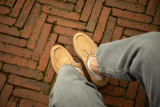 Tan shoes on a patterned brick path in a rustic setting