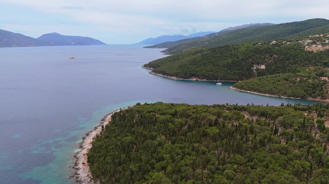 4K drone footage flying over dense green cypress forests towards the blue Ionian Sea in Evreti, Kefalonia Island, Greece