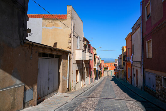 Traditional narrow street with colorful houses in the town of Sant'Antioco, Sardinia, Italy