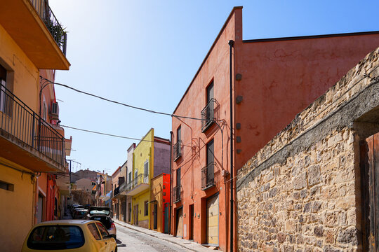 Traditional narrow street with colorful houses in the town of Sant'Antioco, Sardinia, Italy