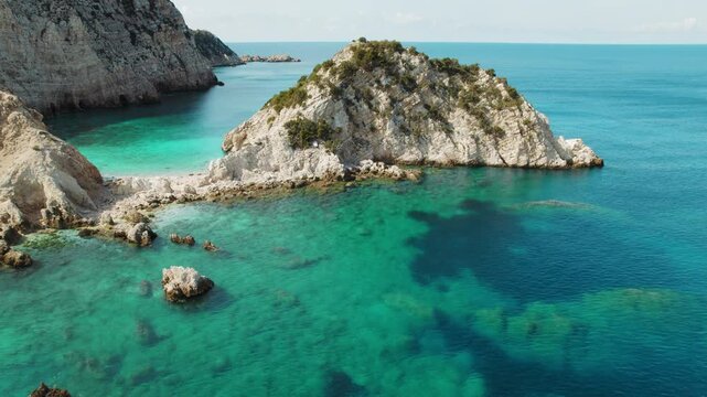 Turquoise bay surrounded by steep rocky cliffs and clear sea waters in Kefalonia