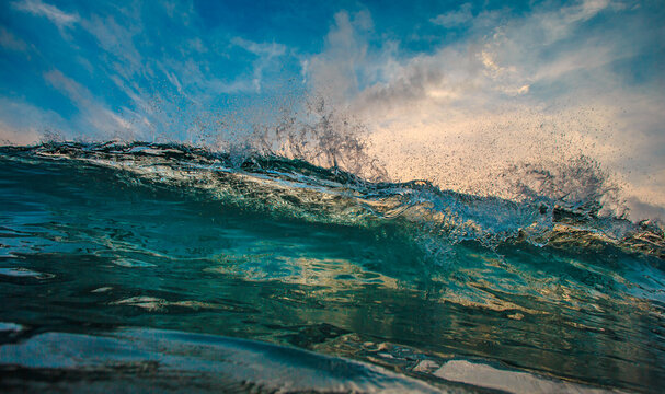 Powerful Ocean Wave Crashing with Water Spray Against Blue Sky