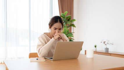 Fototapeta premium Asian woman are stressed, pain in their eyes, working on laptop in living room at home