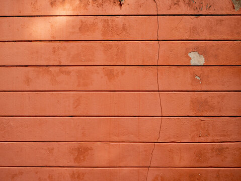 Weathered Red Orange Painted Concrete Wall with Cracks and Peeling Paint, Grunge Urban Texture