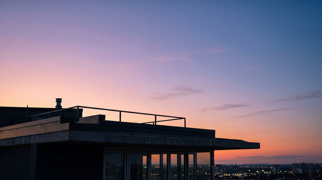 Modern rooftop penthouse silhouette at twilight over city skyline