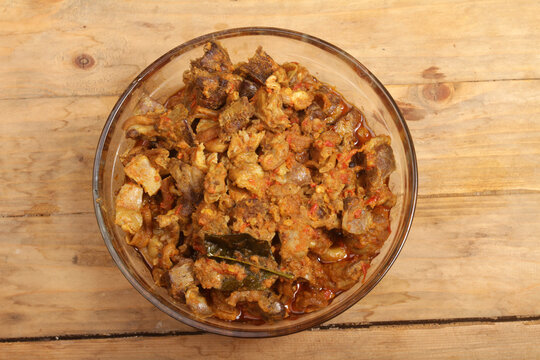 a bowl of sambal goreng ati on wooden table
