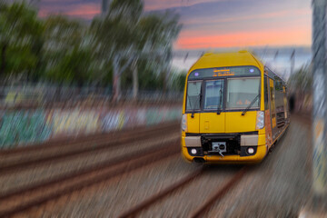 Fototapeta premium Passenger Train going through Lewisham Train Station at Sunset a suburban Sydney train Station in Sydney NSW Australia