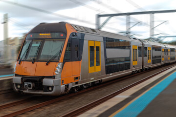 Obraz premium Passenger Train going through Lewisham Train Station at Sunset a suburban Sydney train Station in Sydney NSW Australia