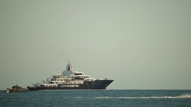 Large private mega yacht sailing through open sea waters, representing wealth, exclusive travel, and luxurious lifestyle