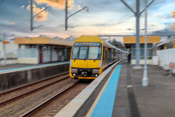 Fototapeta premium Passenger Train going through Lewisham Train Station at Sunset a suburban Sydney train Station in Sydney NSW Australia