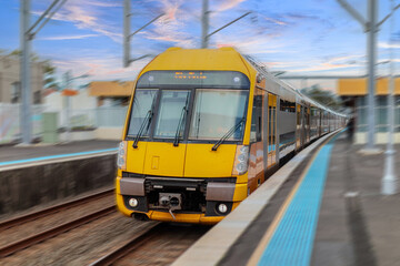 Fototapeta premium Passenger Train going through Lewisham Train Station at Sunset a suburban Sydney train Station in Sydney NSW Australia