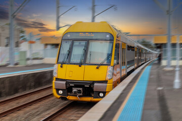 Fototapeta premium Passenger Train going through Lewisham Train Station at Sunset a suburban Sydney train Station in Sydney NSW Australia