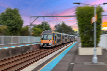 Obraz premium Passenger Train going through Lewisham Train Station at Sunset a suburban Sydney train Station in Sydney NSW Australia