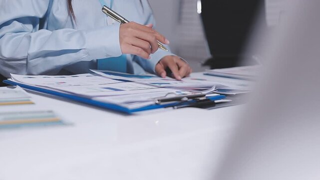 Accountant woman working on financial investment on calculator, calculation, business growth analysis and marketing on graph at office.