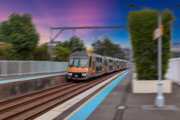 Passenger Train going through Lewisham Train Station at Sunset a suburban Sydney train Station in Sydney NSW Australia © Elias Bitar