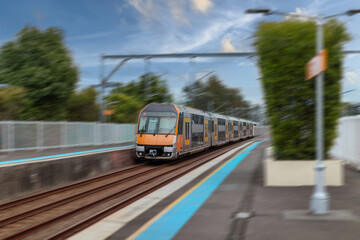 Obraz premium Passenger Train going through Lewisham Train Station at Sunset a suburban Sydney train Station in Sydney NSW Australia