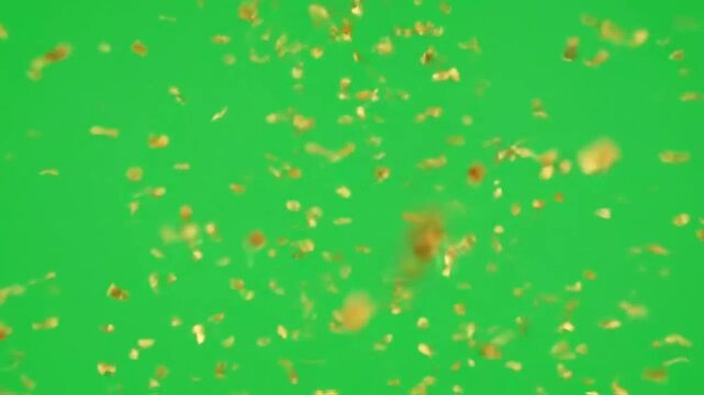 Shiny golden confetti pieces falling down against a vibrant green background