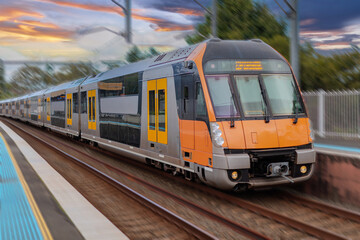 Obraz premium Passenger Train going through Lewisham Train Station at Sunset a suburban Sydney train Station in Sydney NSW Australia