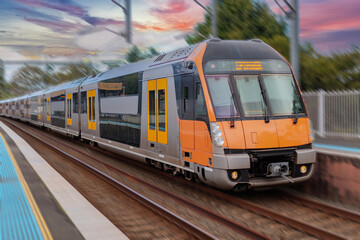 Naklejka premium Passenger Train going through Lewisham Train Station at Sunset a suburban Sydney train Station in Sydney NSW Australia