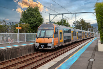 Obraz premium Passenger Train going through Lewisham Train Station at Sunset a suburban Sydney train Station in Sydney NSW Australia