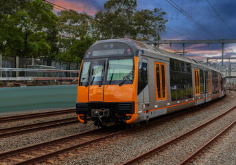 Obraz premium Passenger Train going through Lewisham Train Station at Sunset a suburban Sydney train Station in Sydney NSW Australia