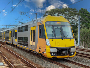 Fototapeta premium Passenger Train going through Lewisham Train Station at Sunset a suburban Sydney train Station in Sydney NSW Australia