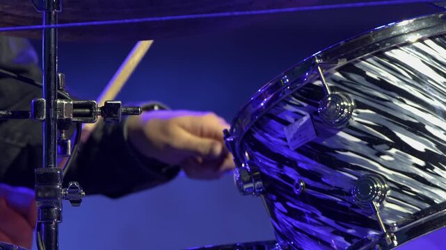 Close up detail of drummer on stage hitting tom tom drums with sticks