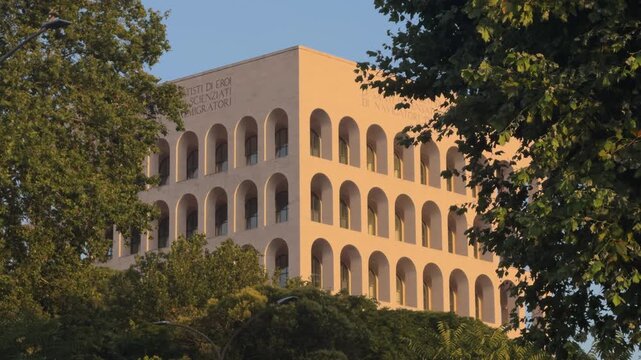 Famous eur district building in rome featuring rationalist architecture with its iconic arches, illuminated by the warm light of sunset