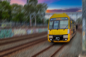 Fototapeta premium Passenger Train going through Lewisham Train Station at Sunset a suburban Sydney train Station in Sydney NSW Australia