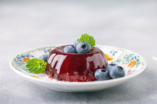 Glossy blueberry jelly dessert garnished with fresh berries