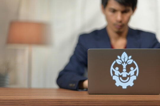 Young Professional Man Using Laptop with Growth and Innovation Logo in Office Setting