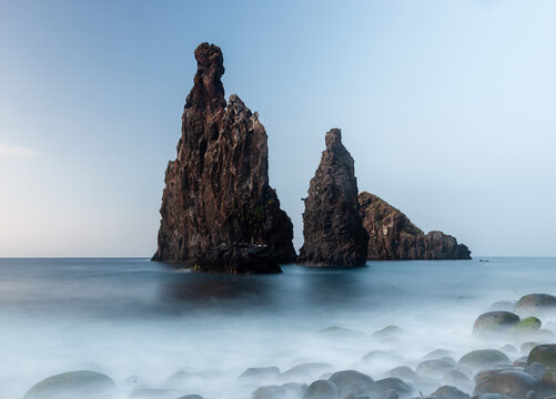 Rock formations rise from the Atlantic at Porto Moniz, Madeira. Rugged sea stacks dominate the coastline. Waves crash against volcanic cliffs. Dramatic coastal scenery on Portugal's shore.