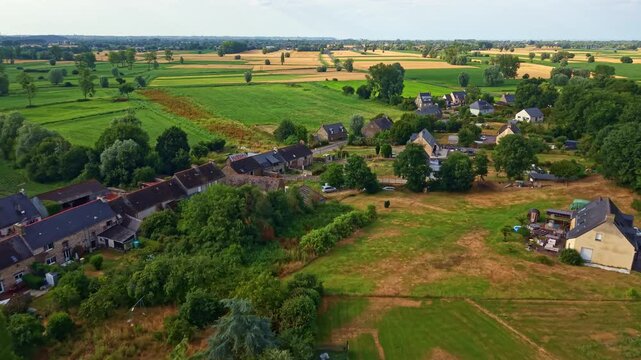 Patchwork farmland, bocage hedgerows, cultivated fields, pasture and rural settlement in Lillemer, Ille-et-Vilaine, Brittany, France, Breton agricultural countryside, drone forward flyover.