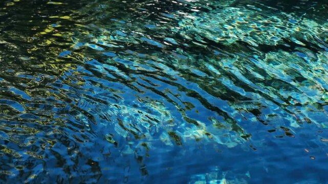 A crystal clear and inviting blue pool of fresh water glistening as light reflects over the gently moving surface