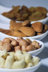 Fototapeta premium dried fruits and nuts on white spoons isolated on white background 