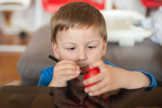 Focused child immersed in the delightful art of Easter egg decoration, creating cherished memories during the holiday season