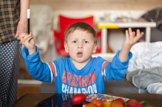 Captivated by creativity a young boy expresses surprise while designing his colorful Easter eggs