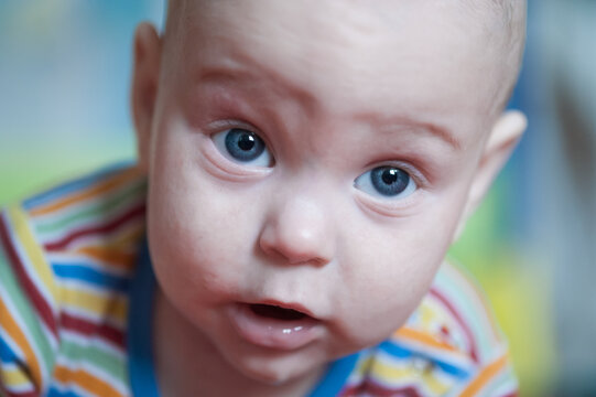 Curious gaze of a sweet infant with striking blue eyes, discovering a vibrant world in a cozy indoor moment