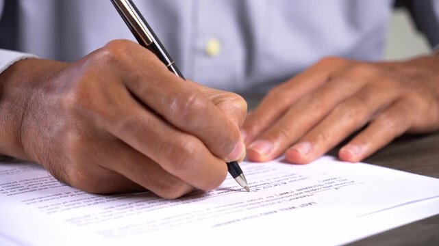 Close Up Shot of Hand Filling Out a Last Will and Testament Form