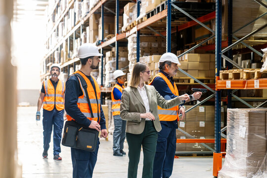 Diverse team of workers and manager discussing inventory and operations in a large logistics and supply chain facility