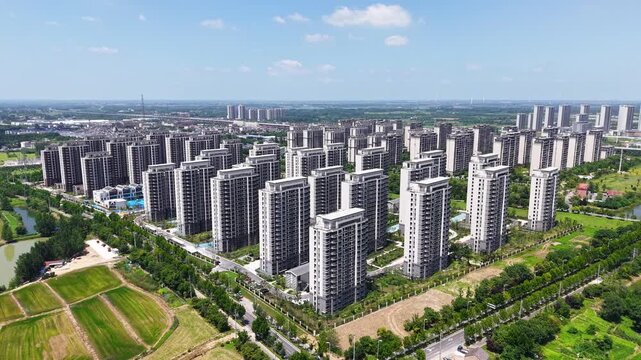 Aerial panoramic view of modern high-rise residential community with green landscape under blue sky
